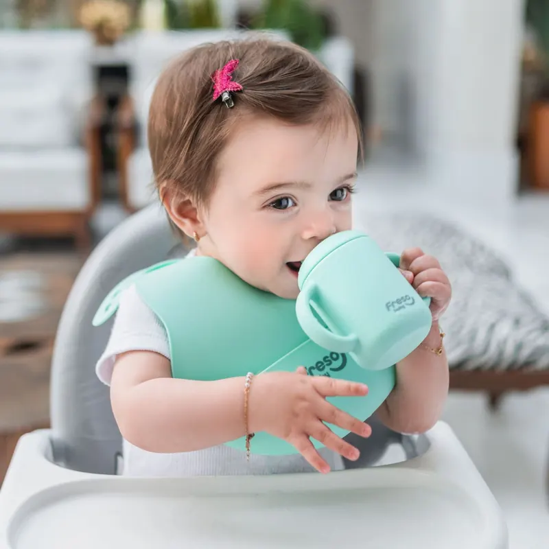 Bebê com o copo Freso verde